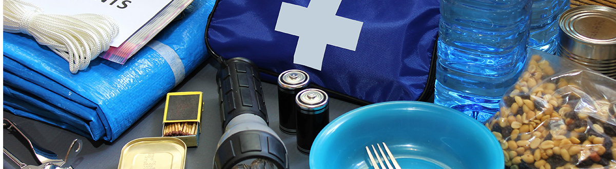 Emergency supplies including water, food, flashlights, batteries, and a first aid kit